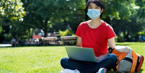 Student wearing a mask with laptop