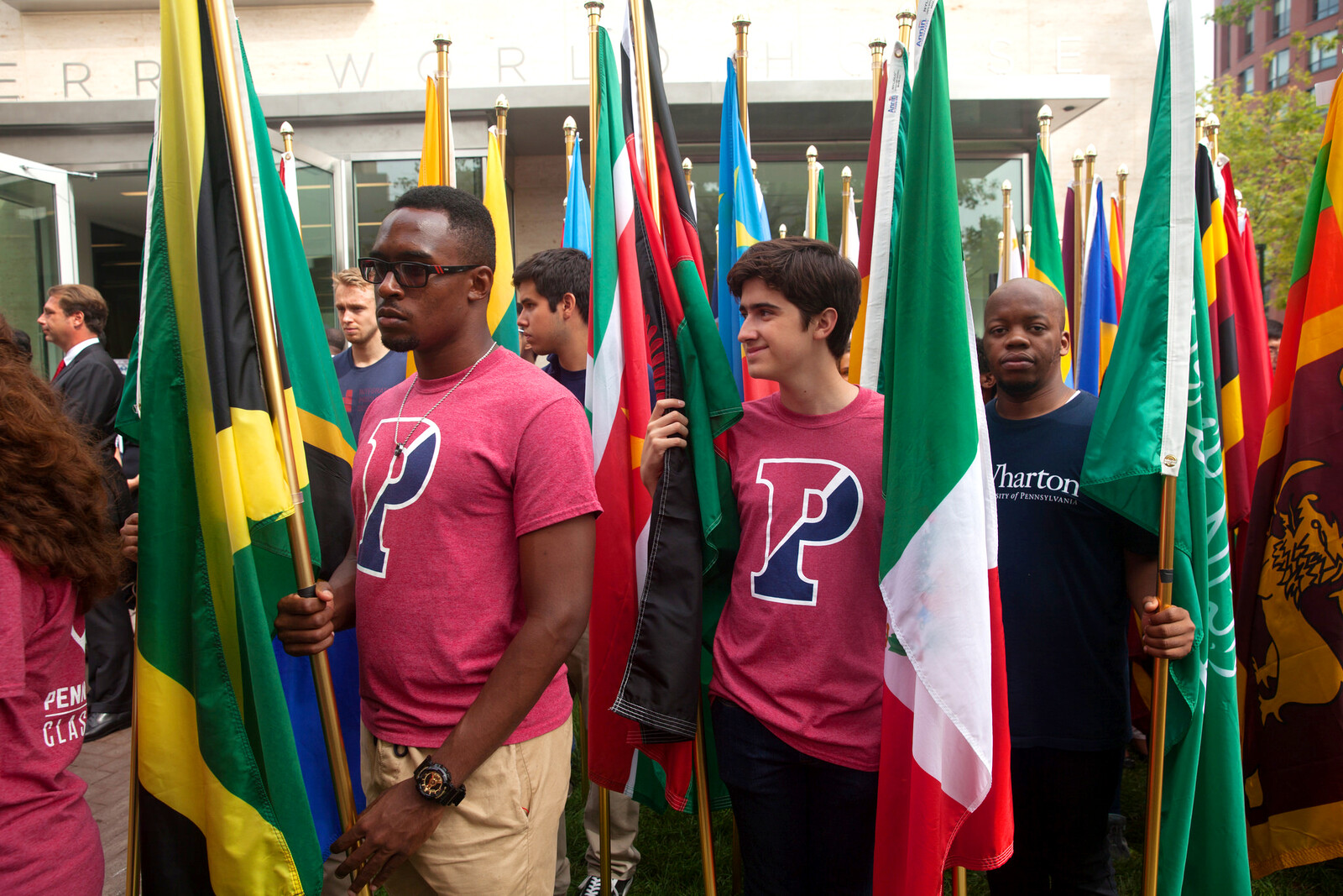 Students holding flags, standing in front of Perry World House
