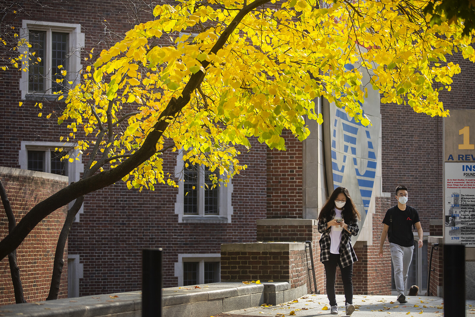 students walking near penn commons in autumn