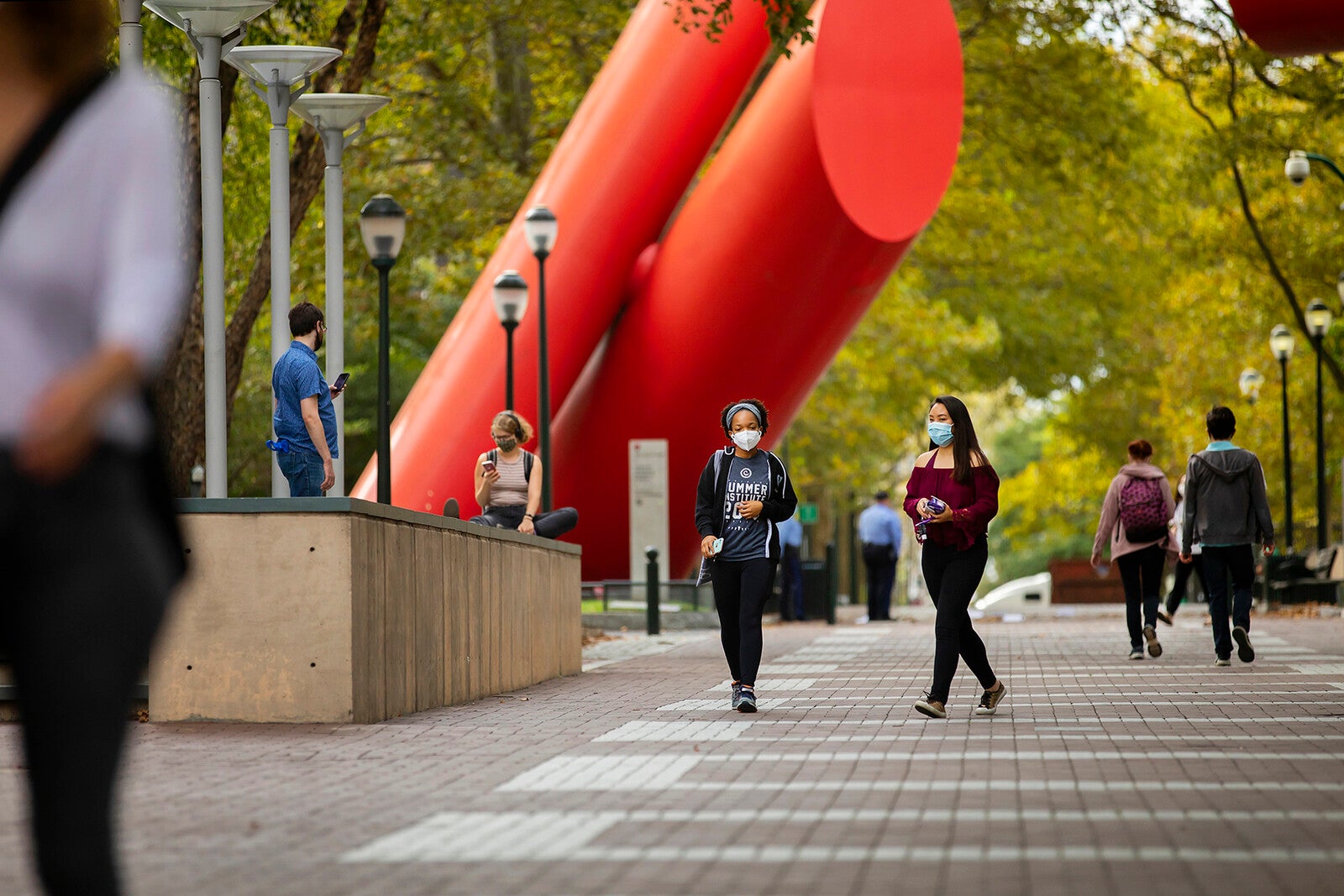 students with masks walking on locust near covenant