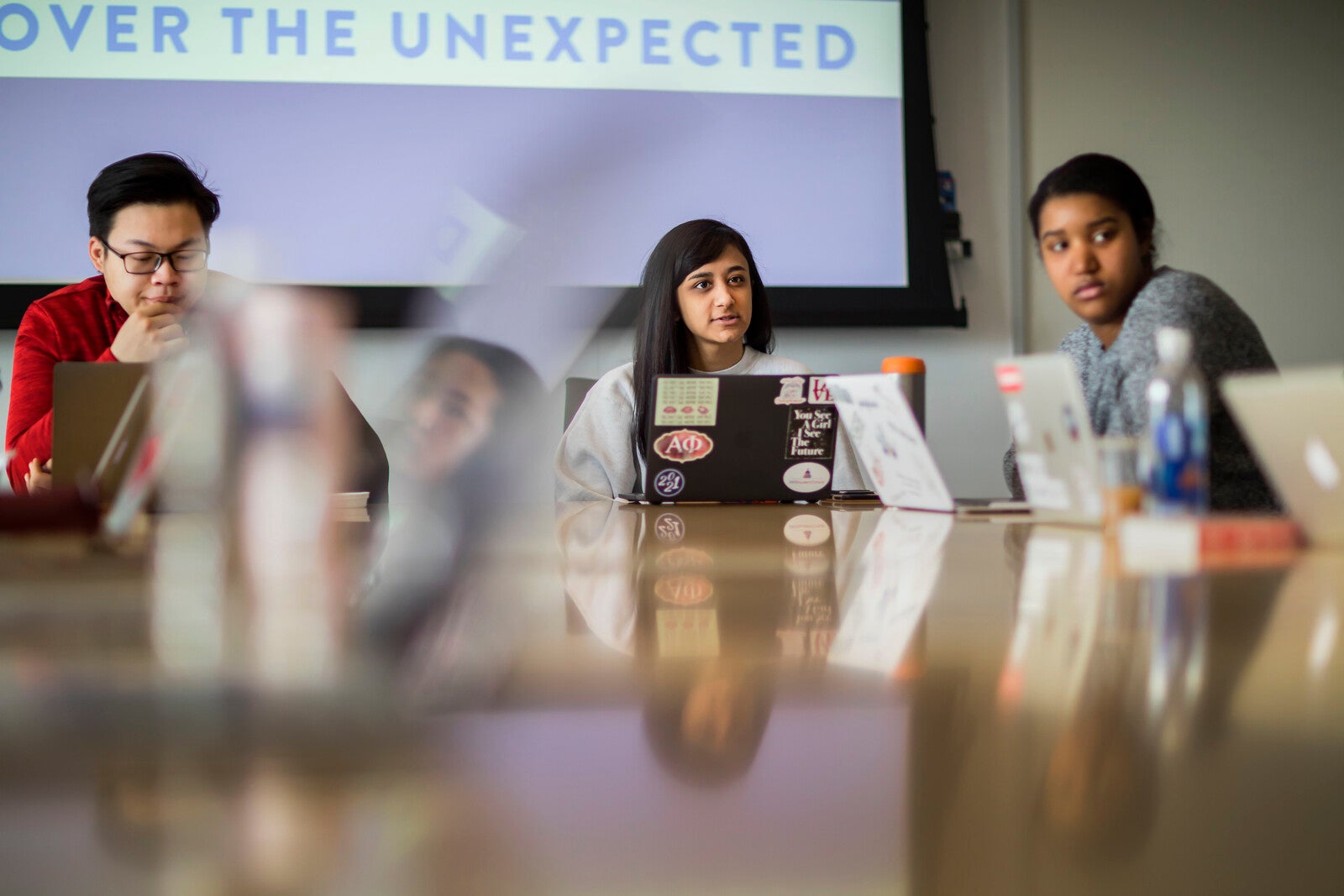 three students on laptops