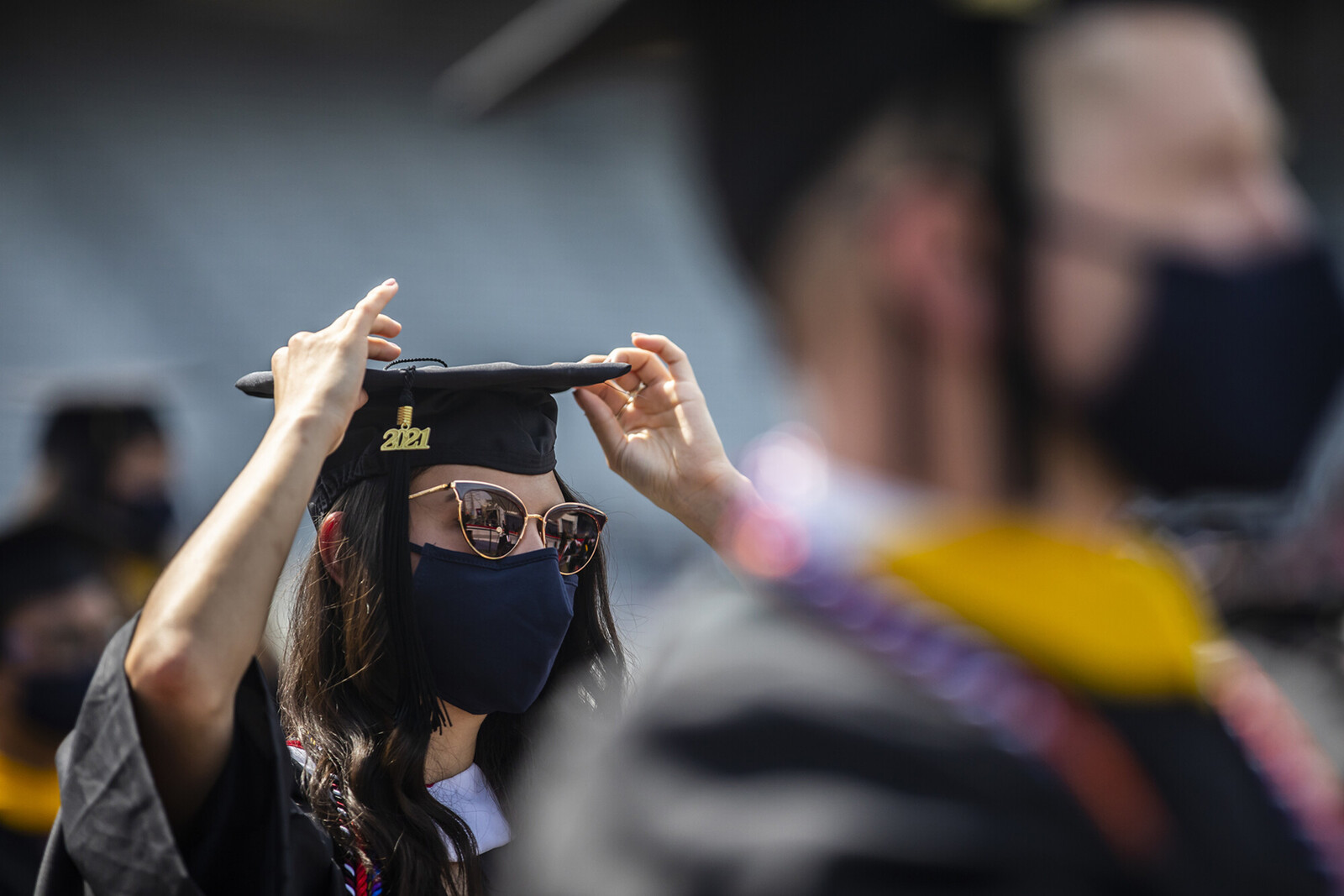 commencement with graduate holding hat