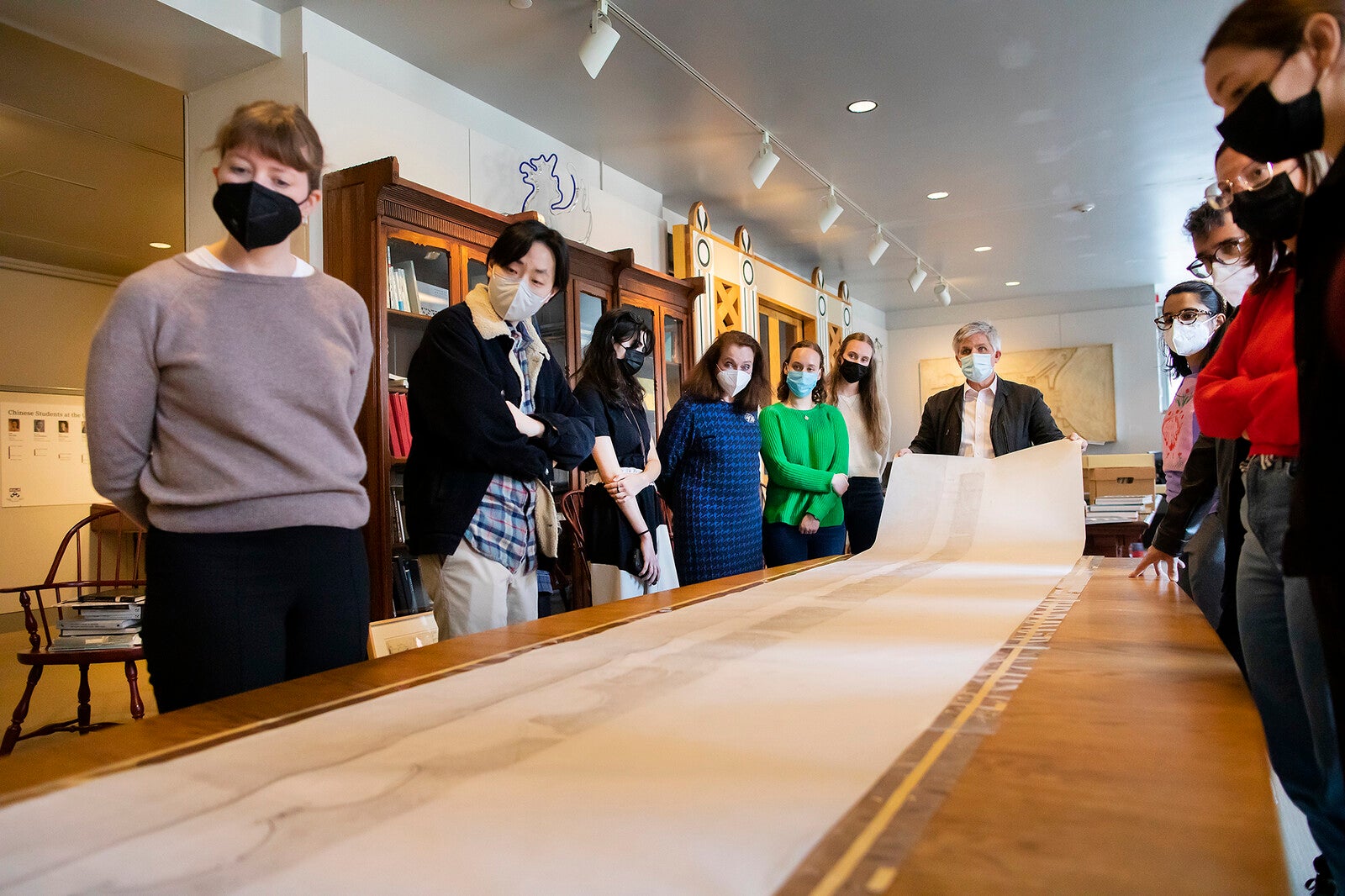 in the archives course, students examining scroll