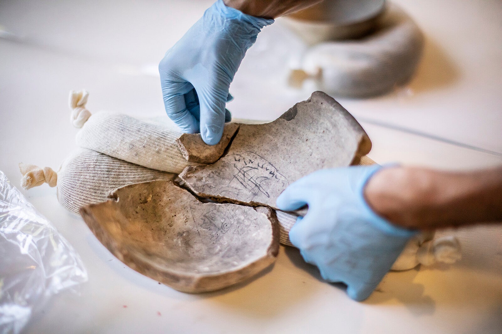 incantation bowl being inspected with gloved hands