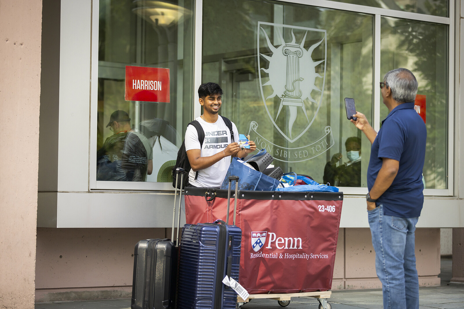 penn student poses with id in front of a dorm