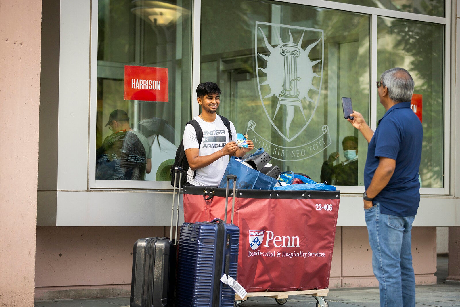 penn student poses with id in front of a dorm