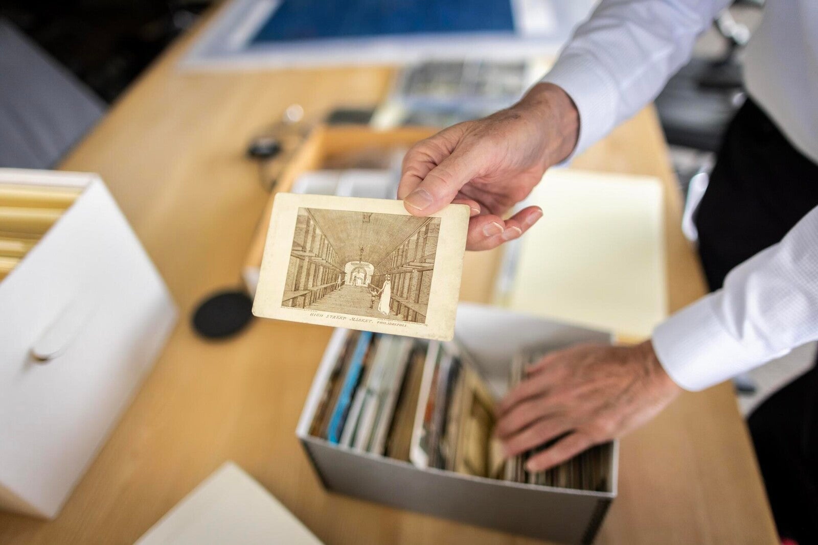 library staff holding an illustration from public markets collection