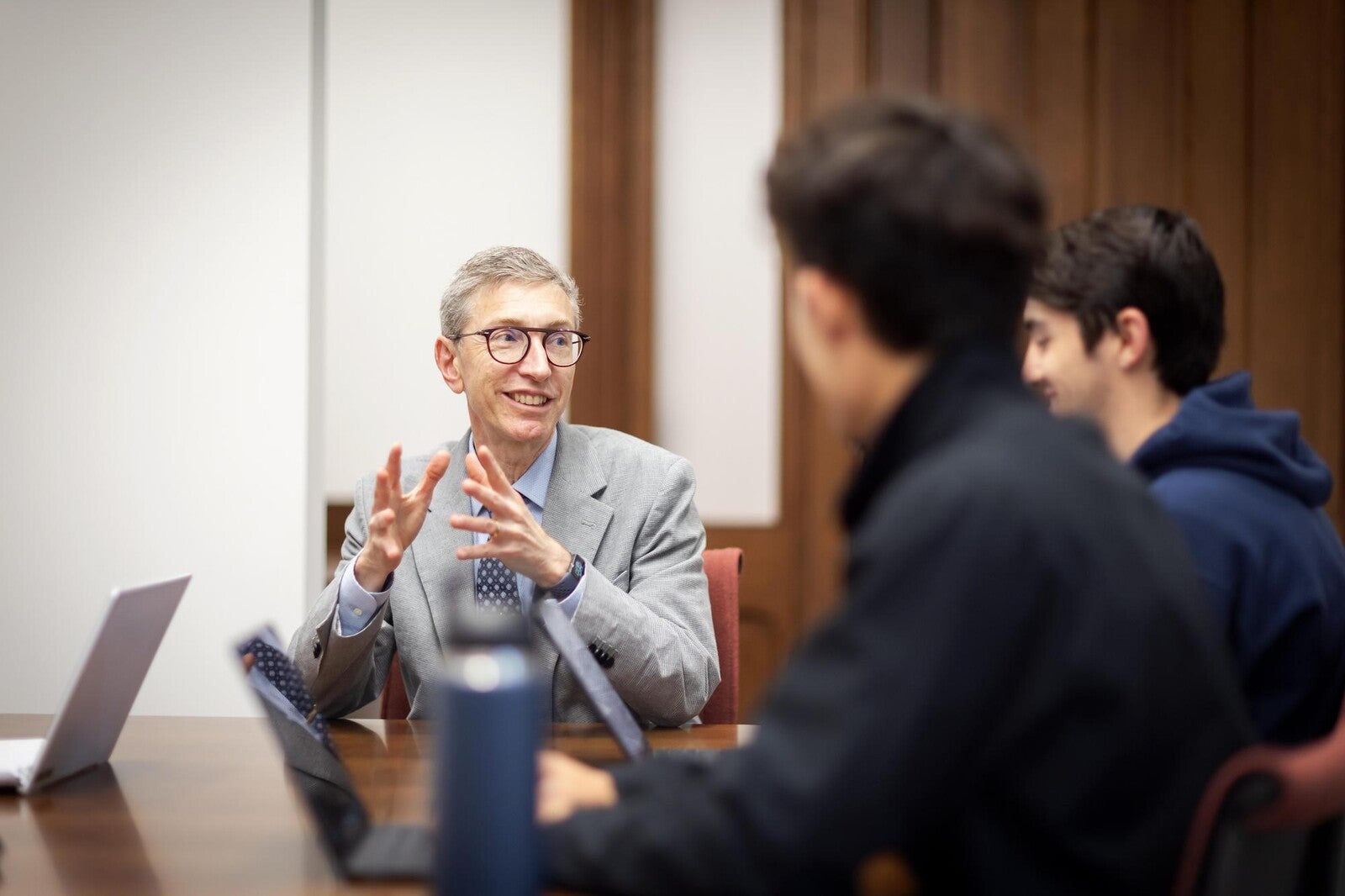 russell composto sitting at a table speaking to staff