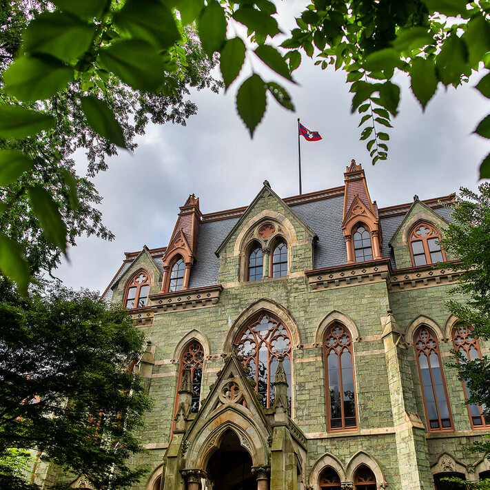 The collegiate gothic exterior of Penn's historic College Hall framed by mature trees 