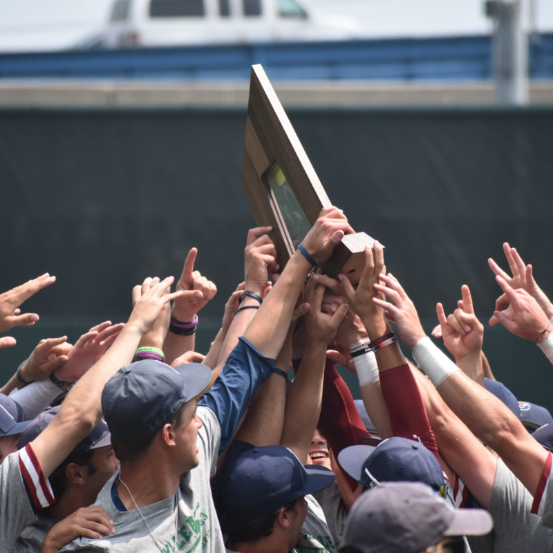 UPenn Baseball team holding championship trophy together