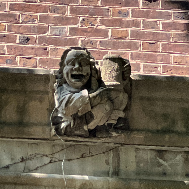 Penn Quad stone gargoyle of someone holding up a cup